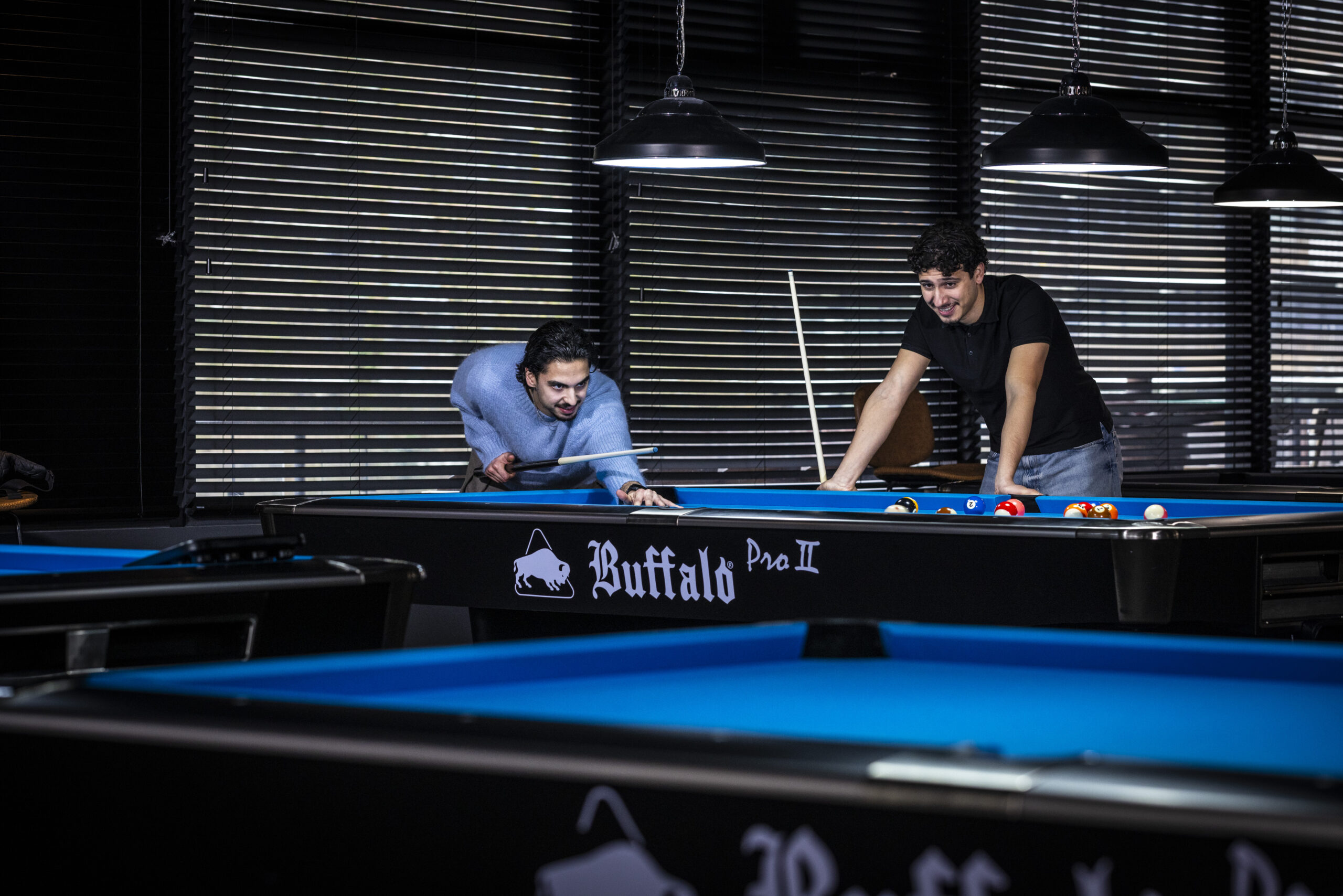 Twee mannen spelen pool aan een pooltafel bij OscarsBowlingPool in Zaandam.