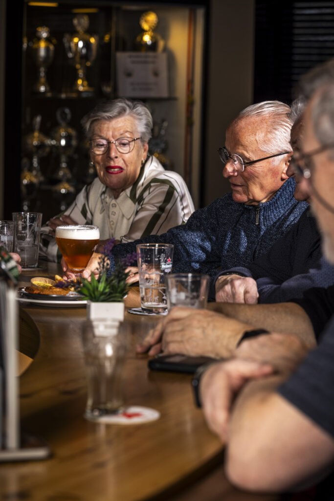 Gezelschap geniet van een drankje aan de bar bij OscarsBowlingPool in Zaandam.